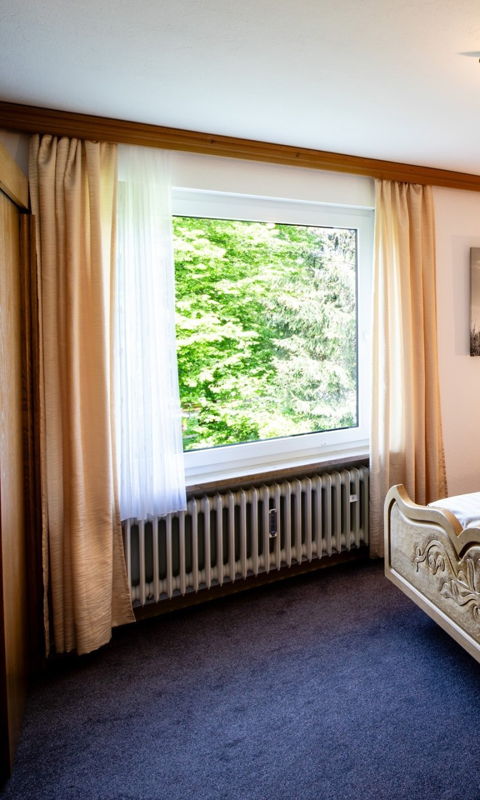 Gemütliches Schlafzimmer mit Holzmöbeln in einer KönigsCard Last Minute Ferienwohnung in Pfronten, Allgäu