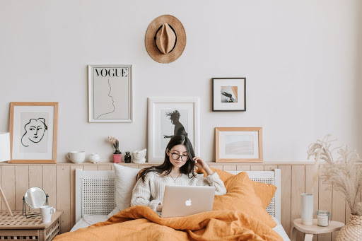 A woman in bed with her legs covered by a blanket, doing her work - Photo by Vlada Karpovich from Pexels