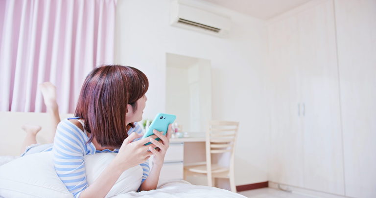 woman creating mini split thermostat schedule with smartphone