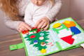 Mother and baby playing with a felt Montessori Christmas book.