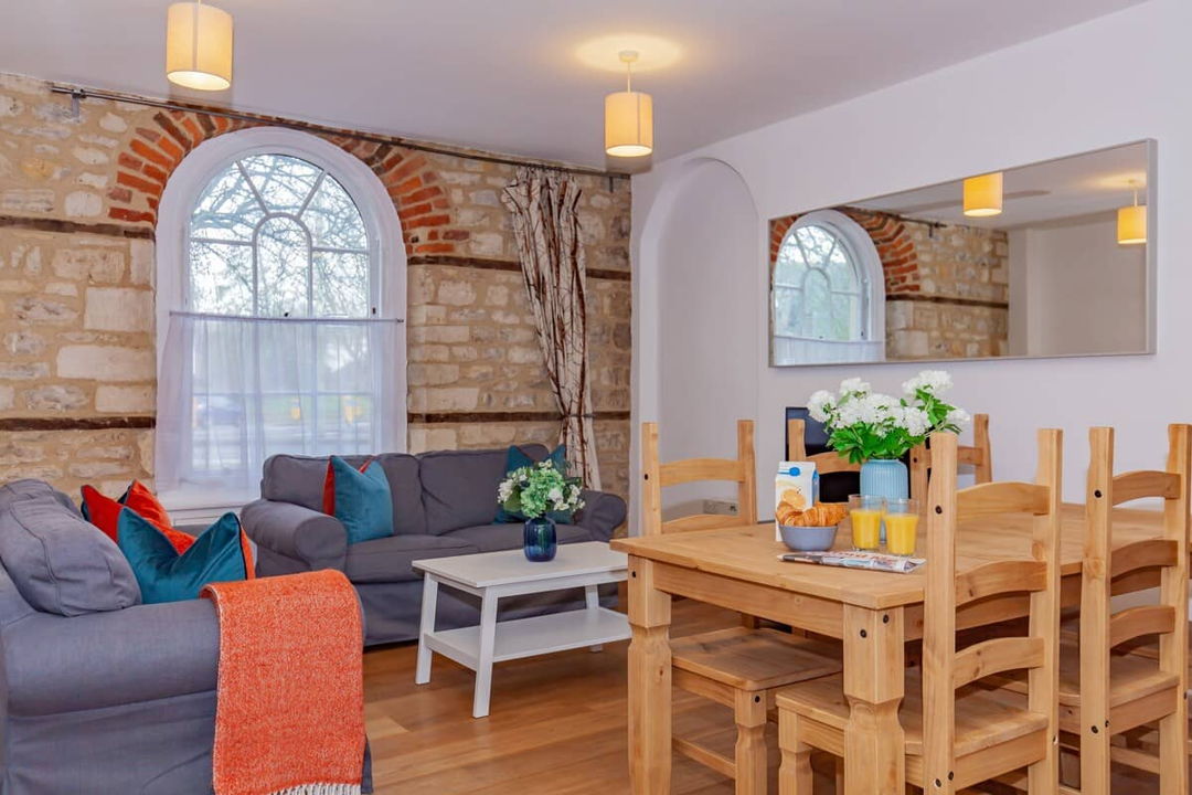 Living room with dining table and exposed brick with arched window