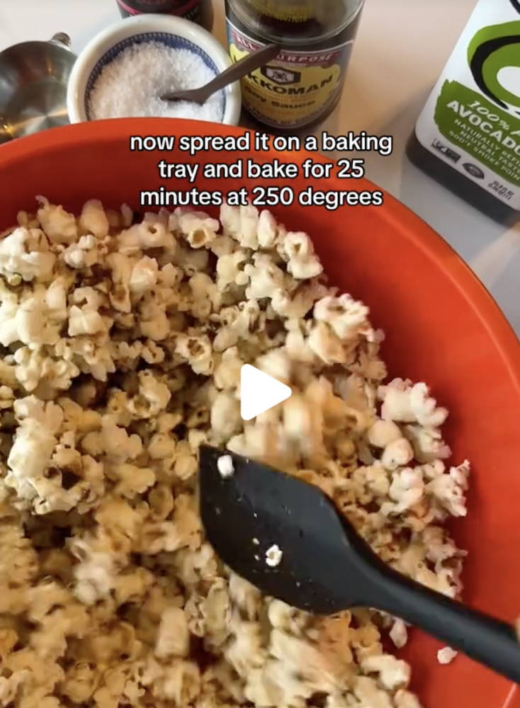 An image of red bowl containing popcorn with the text 'Now spread it on a baking tray and bake for 25 minutes at 250 degrees'