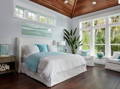 master bedroom with white slipcovered upholstered bed and aqua accents