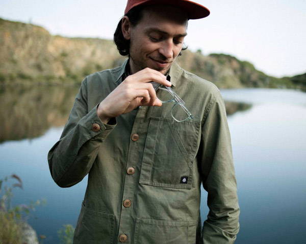 Man wearing organic cotton workwear shirt with corozo nut buttons in Khaki from Cornish based men's sustainable clothing brand The Level Collective in the UKg