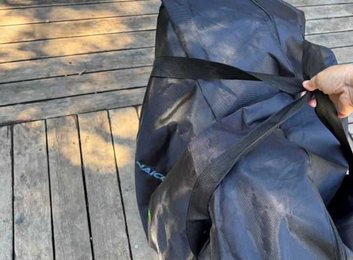 自転車を入れた輪行バッグを持つ