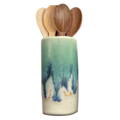 A white and blue vase is filled with dark colored wooden spoons