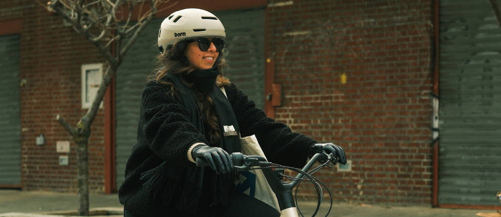 woman riding a bike in a coat and scarf