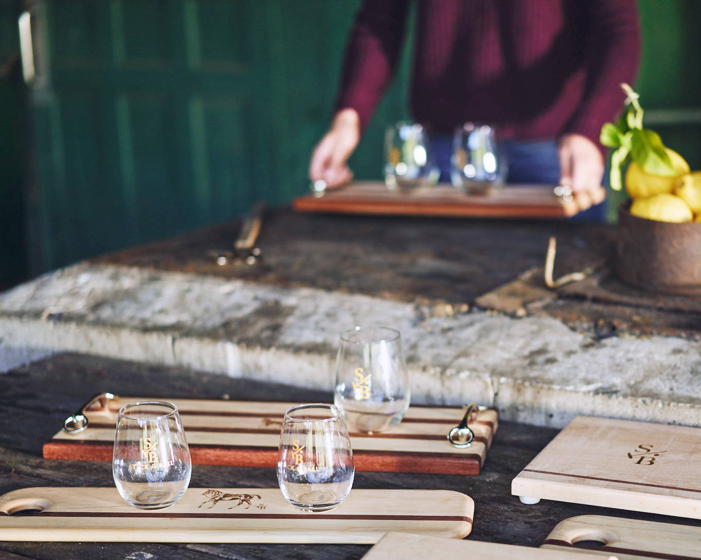 Outdoor display of entertaining serving boards & stemless wine glass with Stick & Ball Logo & Signature Polo Pony 