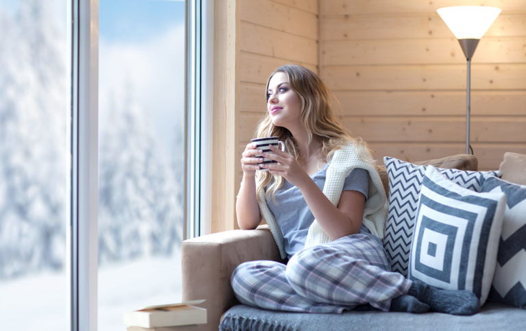 a woman drinking tea and looking out the window