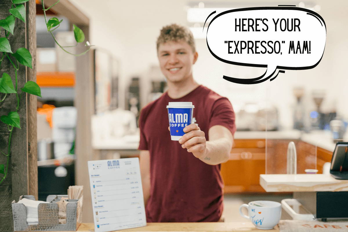 Barista holding a to-go cup of coffee