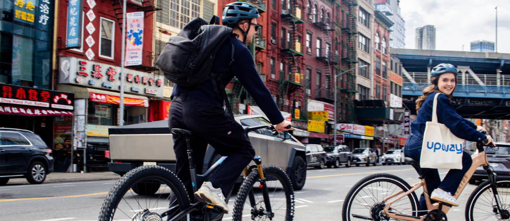 a couple riding ebikes through Chinatown