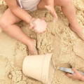 Toddler playing with Montessori Silicone Beach Set in the sand.