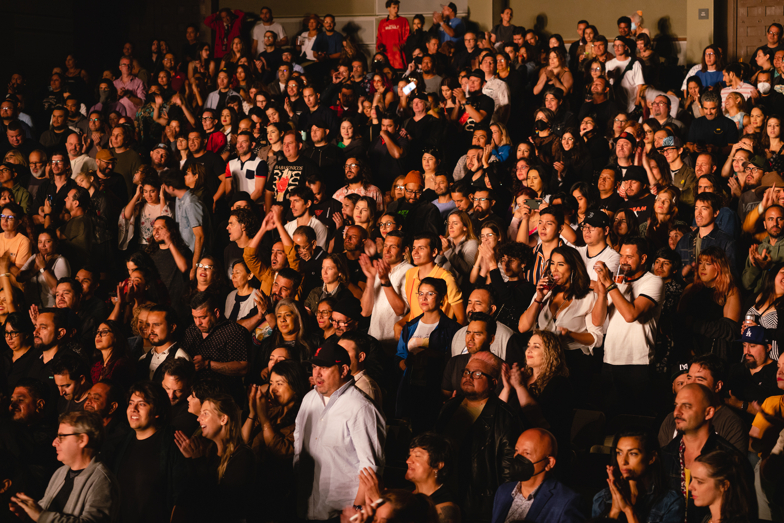 A packed audience is on their feet clapping and cheering for the performers on stage at The Ford