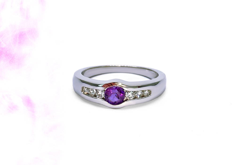 White gold ring with an amethyst as main stone and 3 small diamonds set on each side 