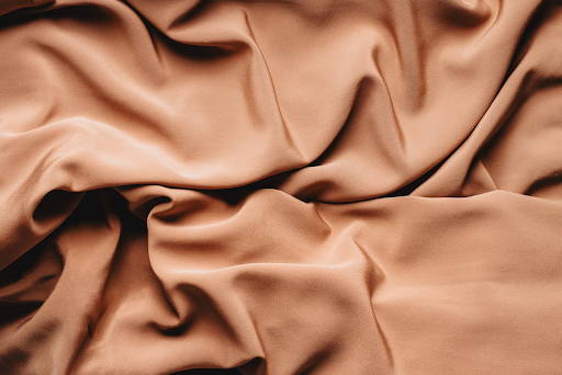 Textured backdrop of crumpled textile with smooth surface
