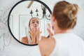 woman applying face mask for dewy skin