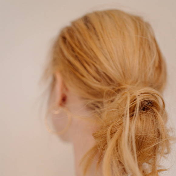 Davines model with blonde short curly hair with bangs