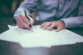 Gros plan sur un homme en train de signer un contrat avec son stylo
