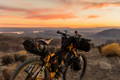 Un vélo équipé pour le bikpacking en pleine nature au coucher du soleil