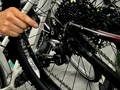 Cycliste réalisant l'entretien de son vélo électrique.