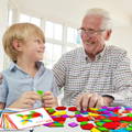 Grandpa and grandson looking at each other and smiling while playing with Montessori Shape Puzzles.