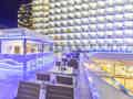 Moderne Hotelterrasse bei Nacht mit der beleuchteten Bar 'La Terracita' und Blick auf illuminierte Balkone.