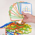 Woman's hand holding a deck of illustrated playing cards above colorful wooden sticks.
