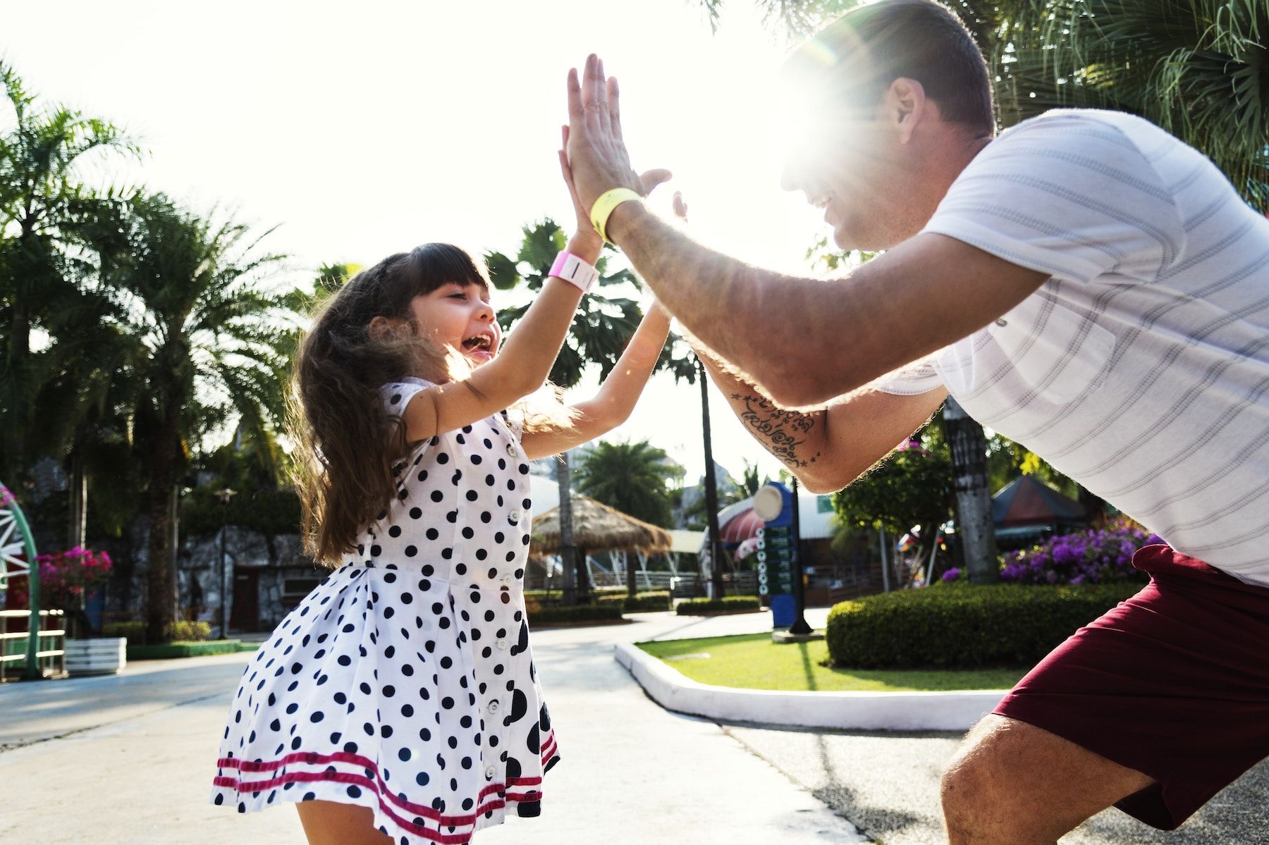 A man high gives a young girl while in the street on a sunny day.