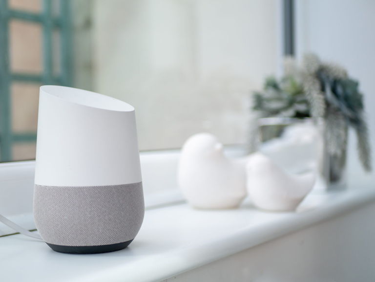 a Google Home smart speaker on a windowsill 