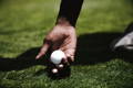Close-up of a golfer setting a golf ball on a tee before teeing off.