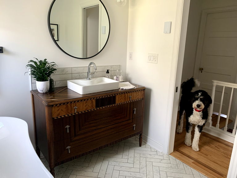 dog in doorway of master bathroom with electric in-floor heating controlled by Mysa