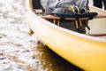 Close up of a canoe in the water with a canoe pack sitting inside of it