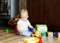 Baby sitting on floor playing with toys during sensory play for babies and early development