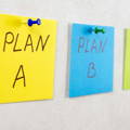 3 posted notes pinned on board saying Plan A, Plan B, and Plan C