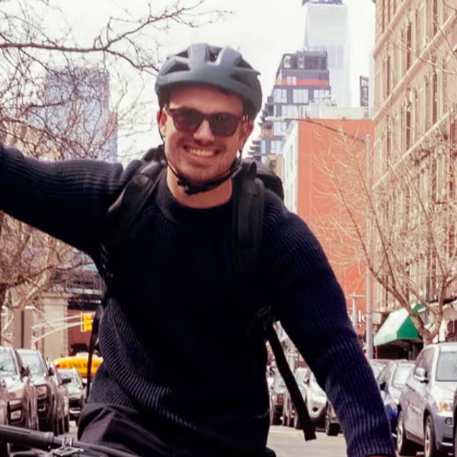 a man riding an electric bike on a busy city street