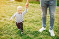 Baby taking steps with a small help from a parent
