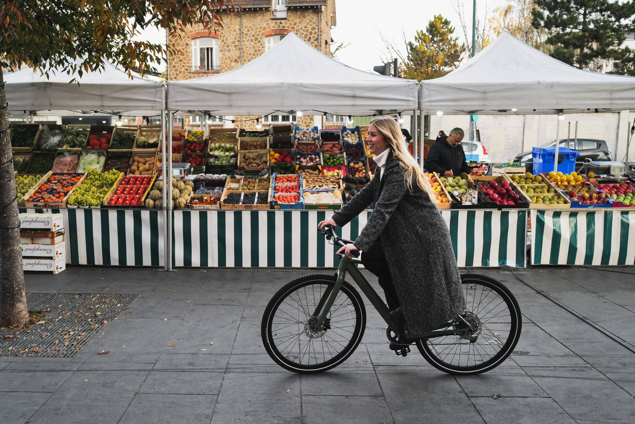 Femme se promenant à vélo électrique au marché.