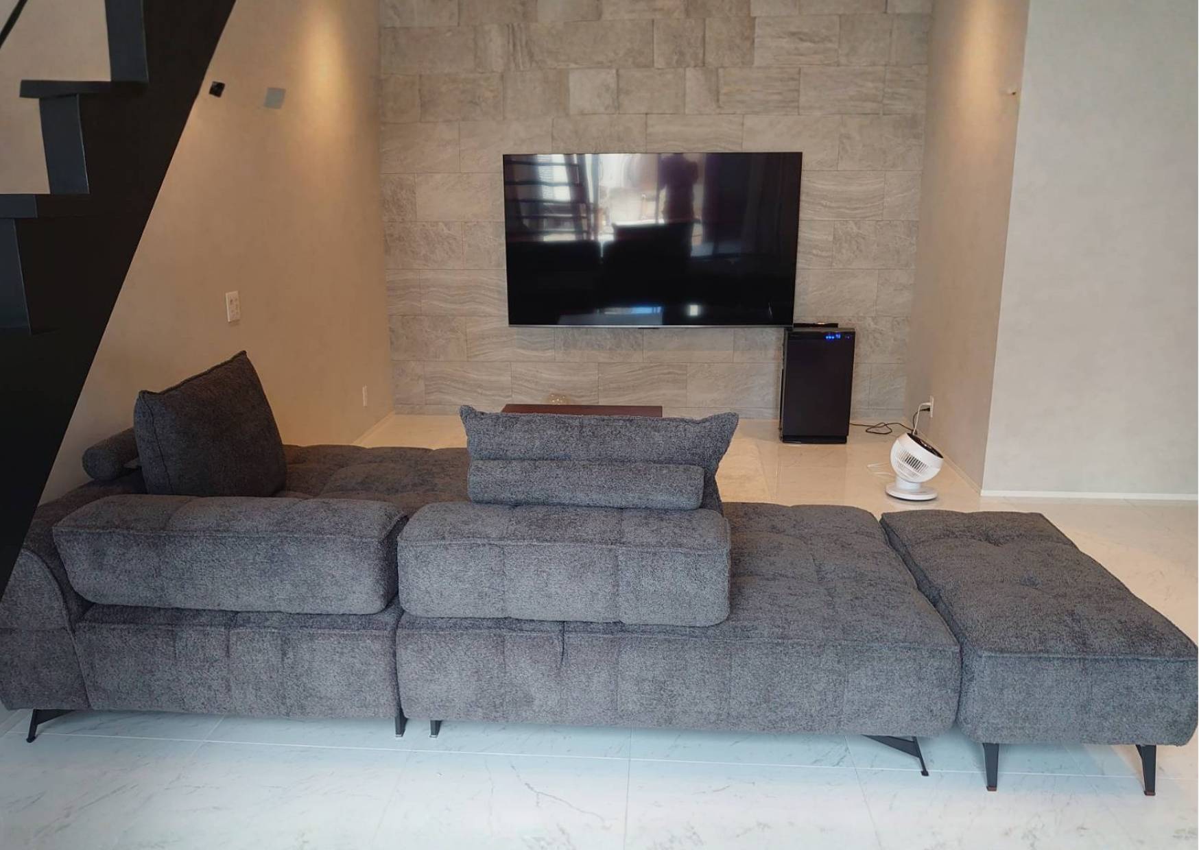 背もたれが可動するグレーの広々ソファを配置したモダンリビング