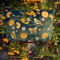 An Elizabeth Scarlett bag hung on a trellis with plants growing all around