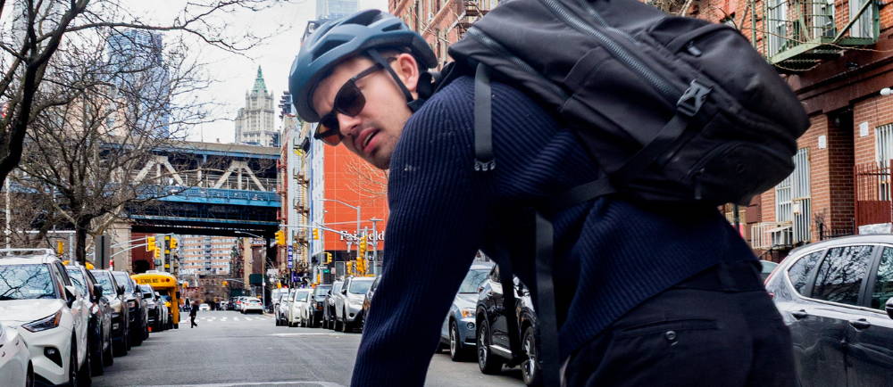 a man with a backpack on a bike in the city