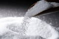 Sugar being poured out of a scoop