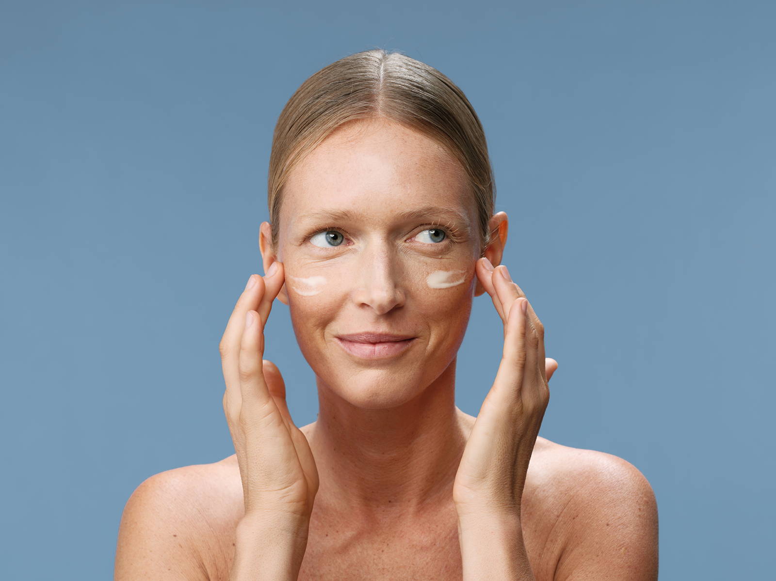 Model applying cream on her face
