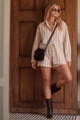 Model in a striped button-up shirt and matching shorts with a black crossbody bag and boots - New to Sale