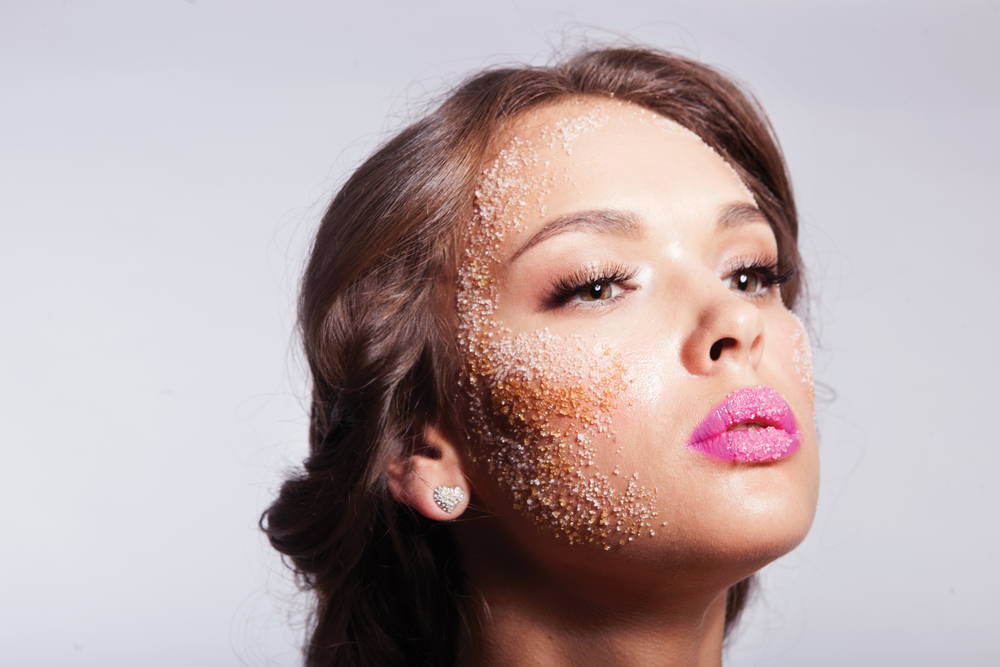 woman's face with sugar all over her skin, showing how it can harm the skin by damaging collagen and increasing breakouts 