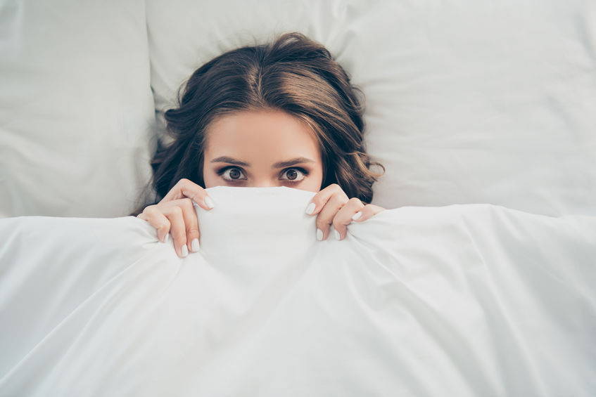 Girl hiding under bedsheet