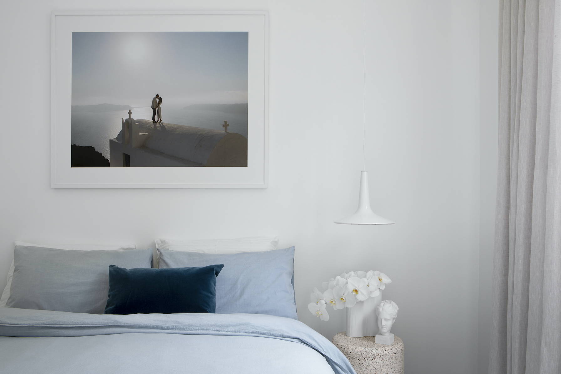 Wedding photography framed and hanging above a beautiful bedroom setting