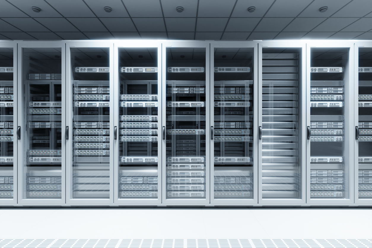 A row of glass-fronted server racks in a modern data center, filled with network servers and equipment, illuminated by bright overhead lighting.