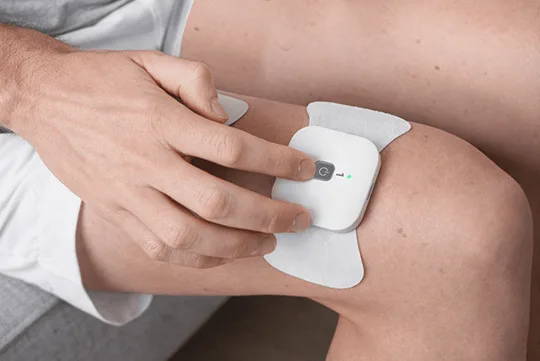 WellueワイヤレスTENSポッドを膝に直接装着して素早くセットアップします。