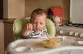 Baby putting a decoration on a birthday cake.