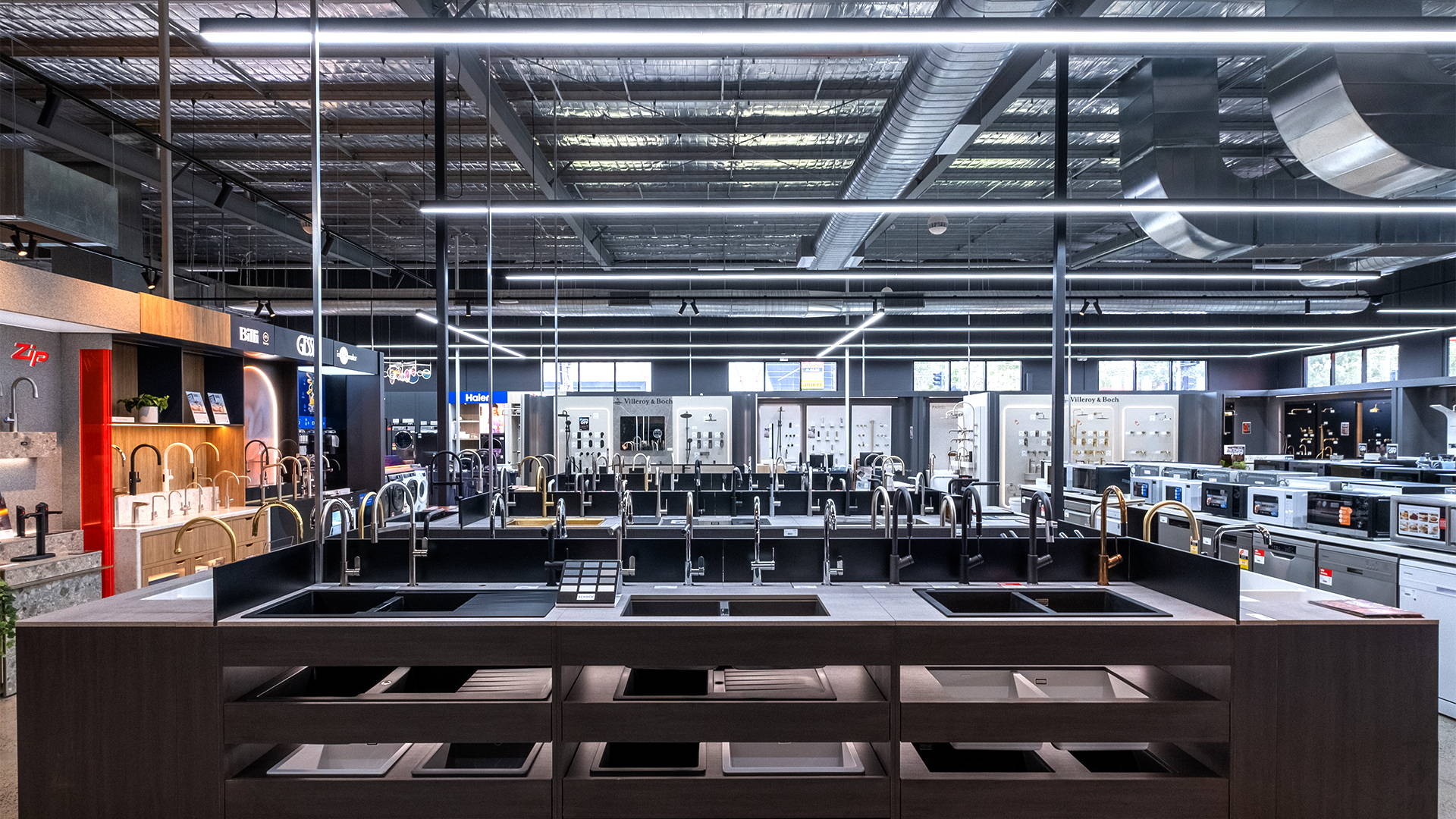 Wide-angle view of a modern commercial space illuminated with energy-efficient pendant lighting and discreet track fittings for clear and focused lighting.